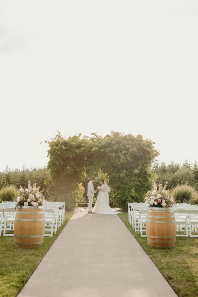 Romantic outdoor wedding reception at Hillside Farms barn wedding venue in Olympia Washington with the greenery arch